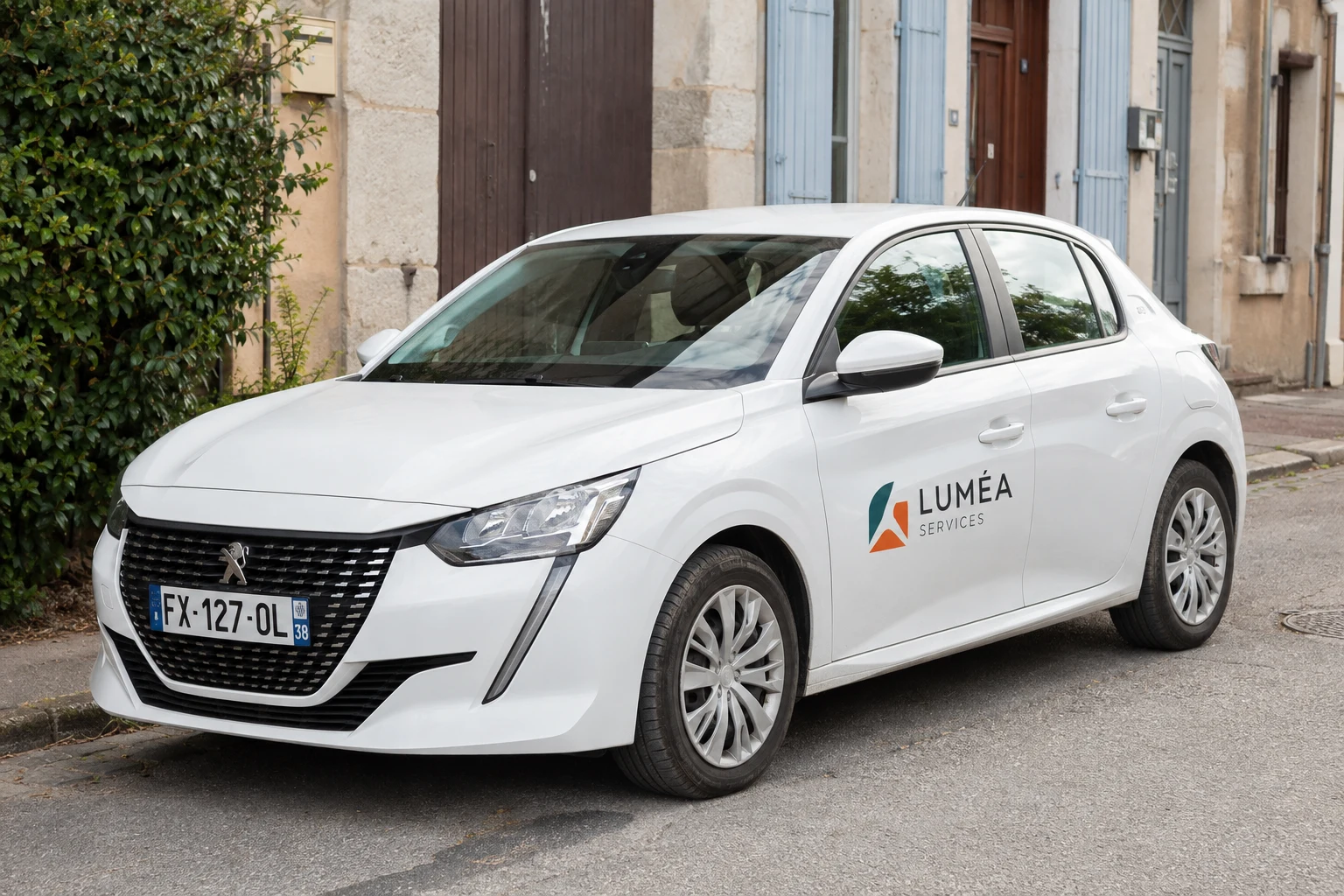 Voiture de société blanche type 208 avec lettrage et logo couleur sur les portes